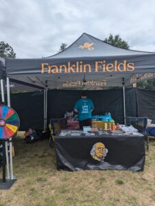 Franklin Fields event collaboration with Lume Cannabis in Hoxeyville Michigan 2024 Event with custom branded tent set up with sales promotions, games and custom branded swag and t-shirts for the event